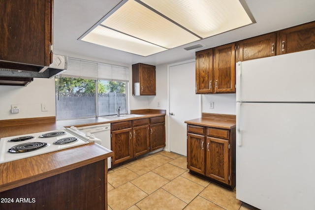 kitchen with sink, white appliances, and light tile patterned flooring