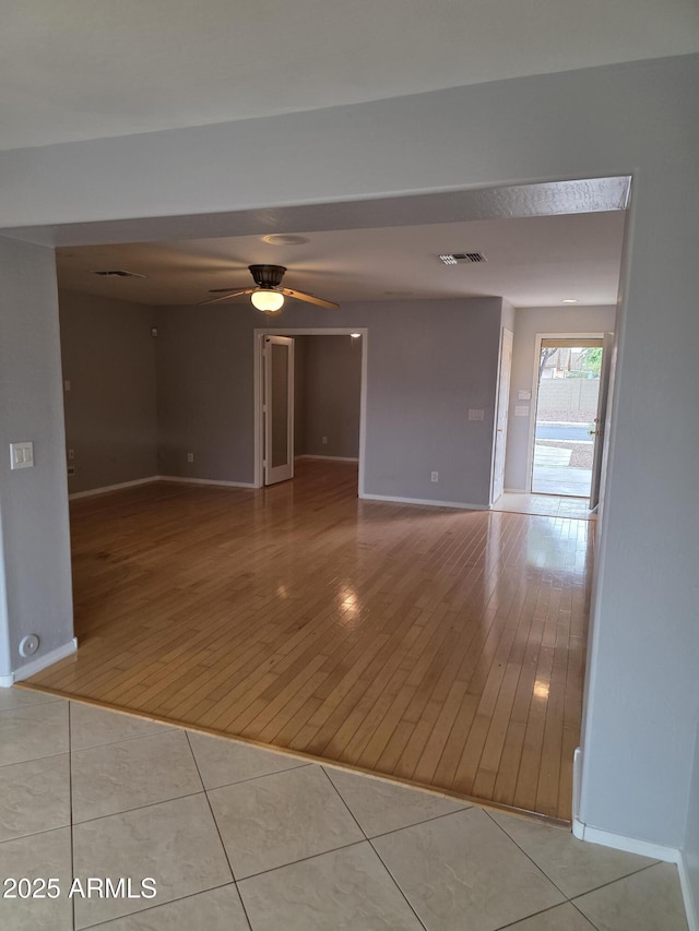 unfurnished room with visible vents, wood finished floors, and baseboards