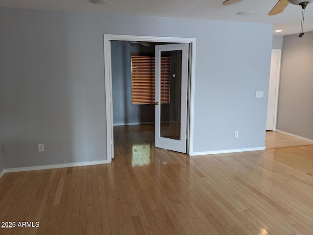 empty room with a ceiling fan, baseboards, and hardwood / wood-style flooring