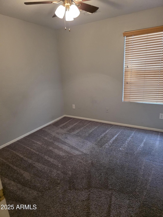 carpeted empty room with baseboards and a ceiling fan