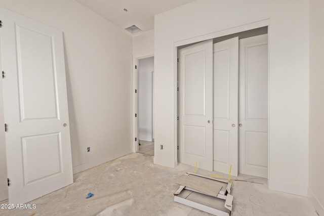 unfurnished bedroom with a closet and baseboards