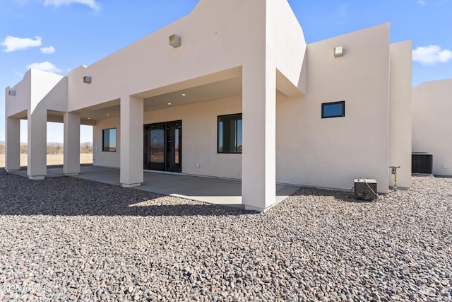 back of house featuring a patio, central AC unit, and stucco siding