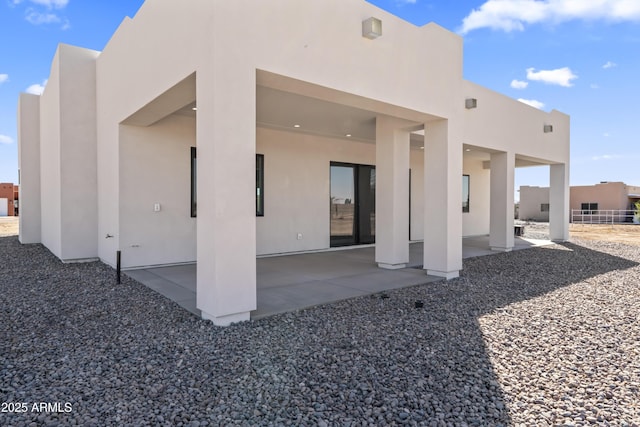 back of house with a patio area, fence, and stucco siding