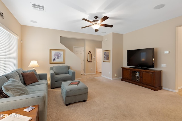 living room with ceiling fan, light colored carpet, and a wealth of natural light