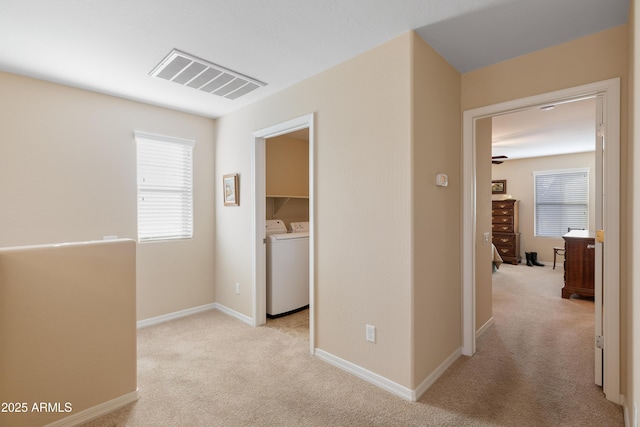 hall featuring light colored carpet and washer and clothes dryer