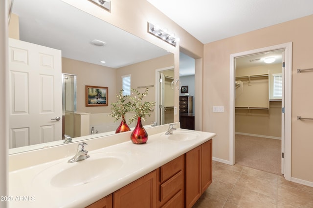 bathroom with a tub to relax in, tile patterned floors, and vanity