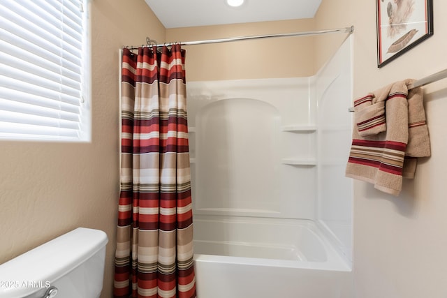 bathroom with shower / bath combination with curtain and toilet