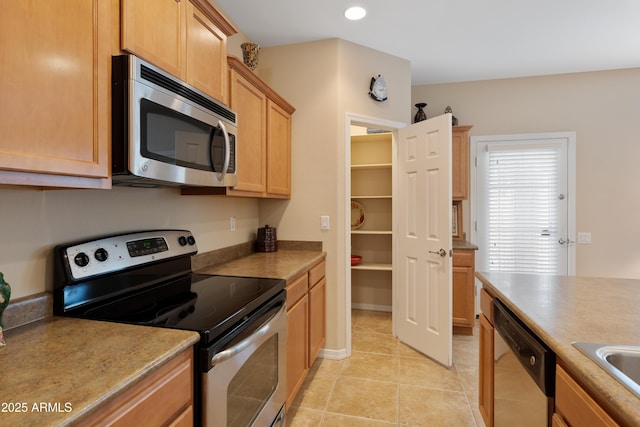 kitchen featuring light tile patterned flooring and stainless steel appliances