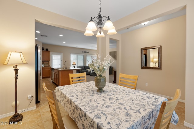 dining space featuring sink and a notable chandelier