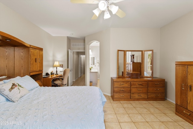 tiled bedroom featuring connected bathroom and ceiling fan