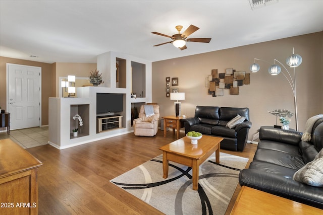 living room featuring hardwood / wood-style floors and ceiling fan