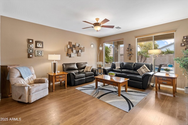 living room featuring wood-type flooring and ceiling fan