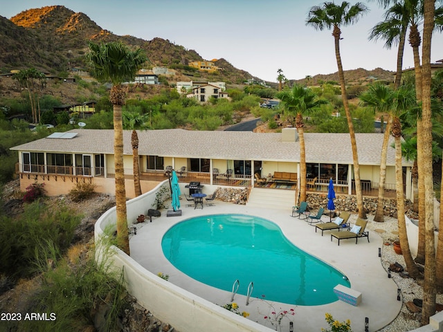 view of swimming pool with a patio and a mountain view