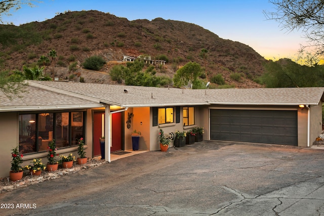 single story home with a garage and a mountain view