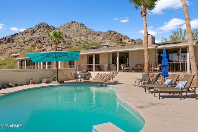 view of swimming pool with a mountain view and a patio area