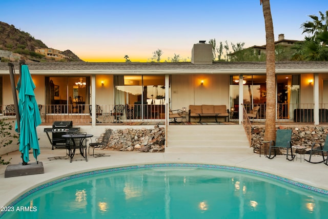 pool at dusk featuring a patio area