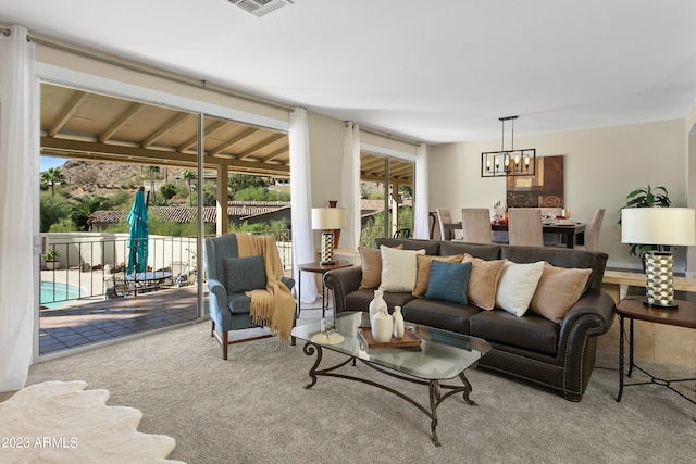 carpeted living room featuring a chandelier