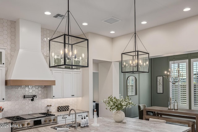 3814 W Running Deer Trl, Phoenix, AZ 85083 - kitchen with a chandelier, custom exhaust hood, light stone countertops, backsplash, and recessed lighting