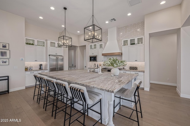 3814 W Running Deer Trl, Phoenix, AZ 85083 - kitchen with stainless steel appliances, premium range hood, a large island with sink, decorative backsplash, and recessed lighting