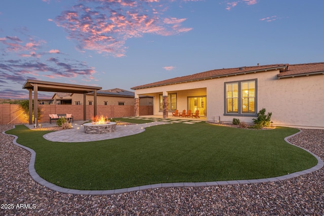 3814 W Running Deer Trl, Phoenix, AZ 85083 - back of house at dusk featuring a patio, a fire pit, and stucco siding