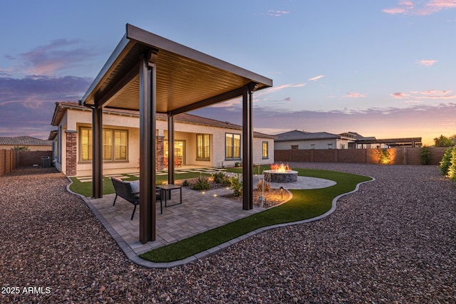 3814 W Running Deer Trl, Phoenix, AZ 85083 - back of house at dusk with an outdoor fire pit, a fenced backyard, a patio, and stucco siding