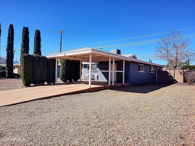 view of front of house with a carport, concrete driveway, and central AC unit