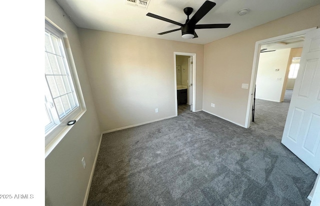 unfurnished bedroom with ceiling fan, visible vents, carpet floors, baseboards, and ensuite bathroom