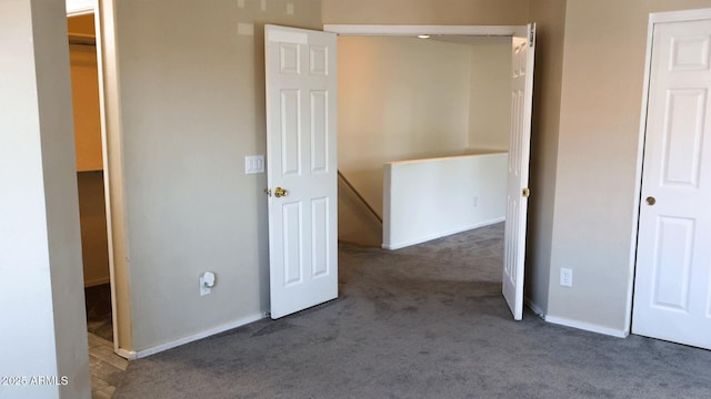 unfurnished bedroom with baseboards and carpet