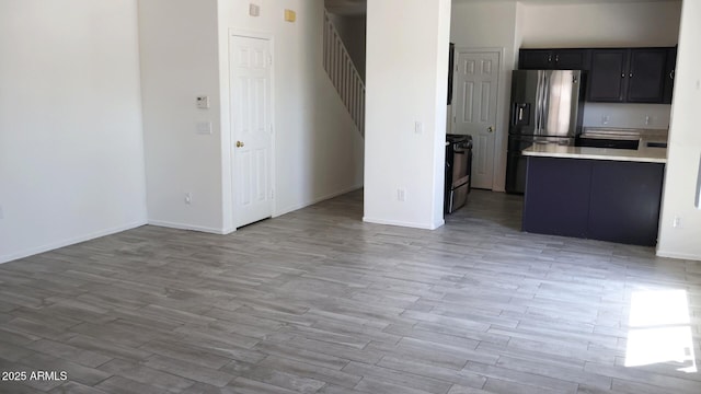 interior space with stairs, baseboards, and light wood finished floors