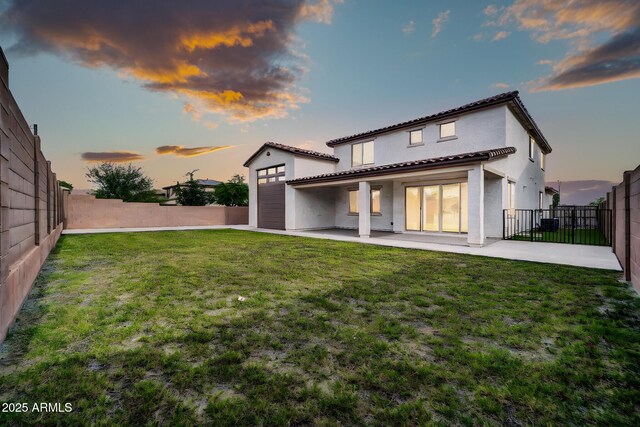 19026 W Becker Ln, Surprise, AZ 85388 - back of property at dusk with a patio area, a tile roof, and stucco siding