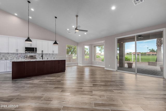 kitchen featuring tasteful backsplash, stainless steel appliances, ceiling fan, high vaulted ceiling, and white cabinets