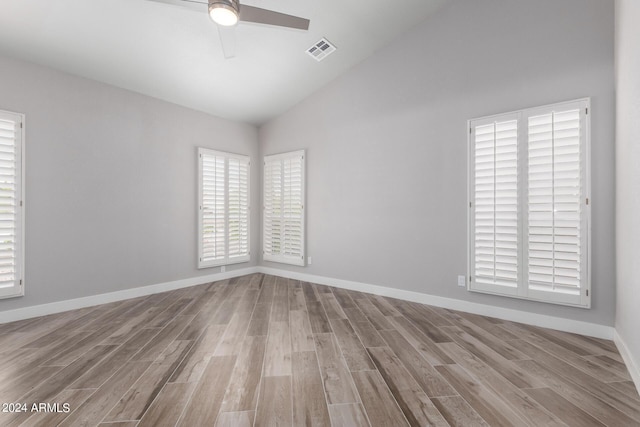 spare room with ceiling fan, light hardwood / wood-style floors, and vaulted ceiling