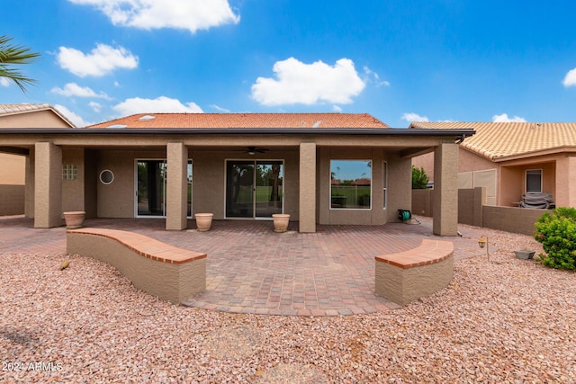 rear view of house with ceiling fan and a patio area