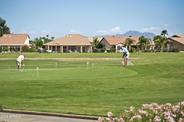 view of home's community with a mountain view and a lawn