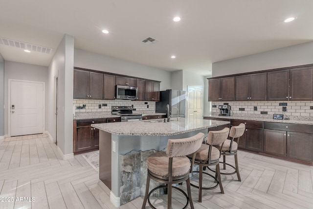 9454 E Alfalfa Dr, Florence, AZ 85132 - kitchen with appliances with stainless steel finishes, backsplash, dark brown cabinets, and recessed lighting