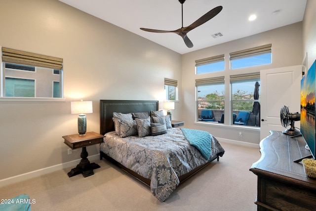 carpeted bedroom featuring ceiling fan and a high ceiling