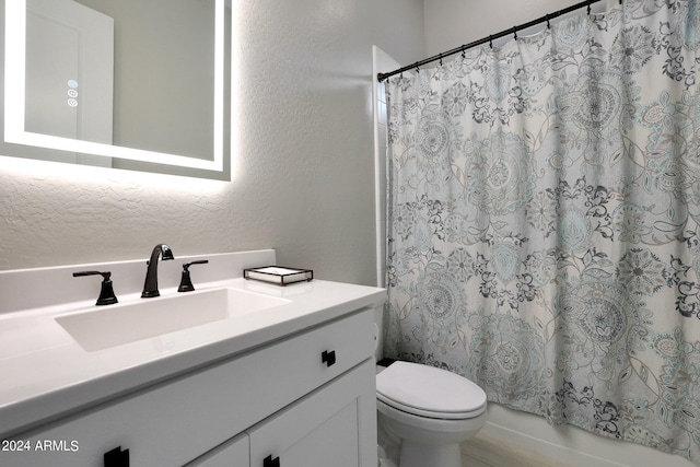 full bathroom with vanity, shower / bath combo, and toilet