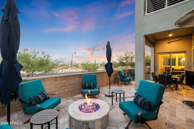 patio terrace at dusk with an outdoor living space with a fire pit