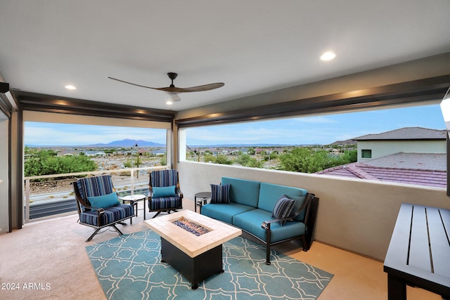 view of patio / terrace with ceiling fan and an outdoor living space with a fire pit