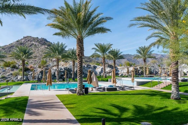 view of community featuring a mountain view, a pool, and a yard