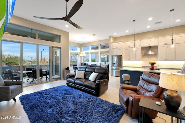 living room featuring a wealth of natural light, ceiling fan, sink, and light tile patterned floors