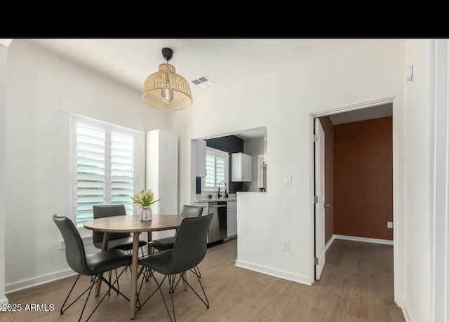 dining room with sink and light hardwood / wood-style flooring