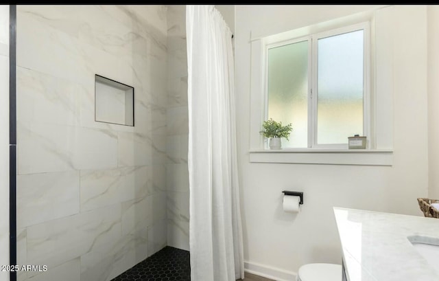 bathroom with walk in shower, vanity, and toilet