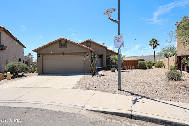 view of front of property featuring a tiled roof, fence, an attached garage, stucco siding, and concrete driveway