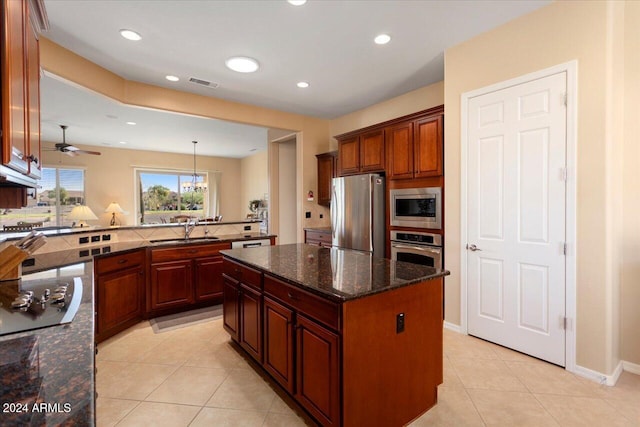 kitchen with sink, a center island, light tile patterned floors, and appliances with stainless steel finishes