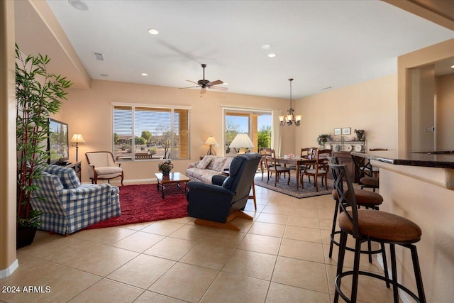 tiled living room featuring ceiling fan with notable chandelier