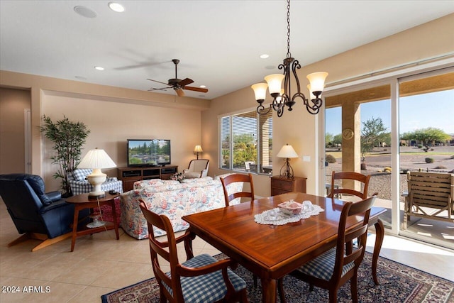 dining space with ceiling fan with notable chandelier and light tile patterned floors