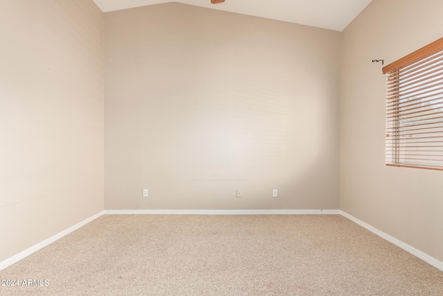 spare room with carpet flooring and lofted ceiling