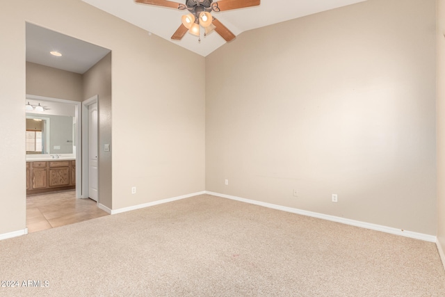 carpeted empty room featuring vaulted ceiling and ceiling fan