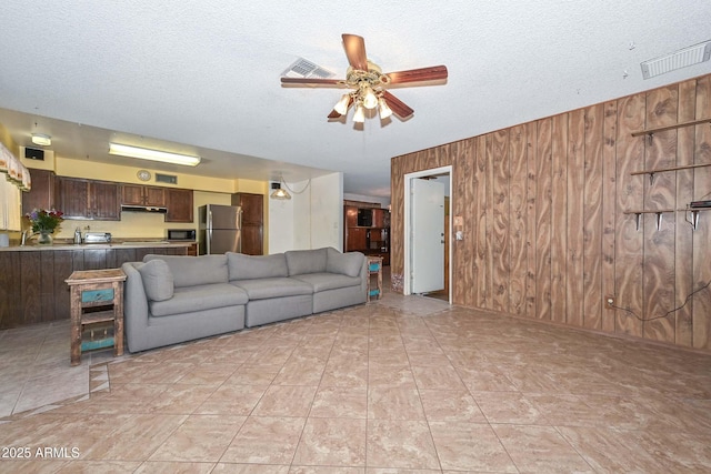 18012 N 37th Dr, Glendale, AZ 85308 - living area with visible vents, a textured ceiling, a ceiling fan, and wood walls